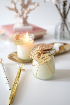 two jars filled with cookies sitting on top of a table next to a pen and notebook