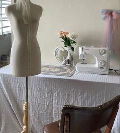 a sewing machine sitting on top of a table next to a dressmaker's mannequin