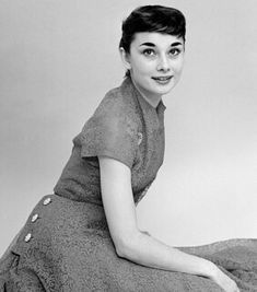 black and white photograph of woman in dress sitting on floor