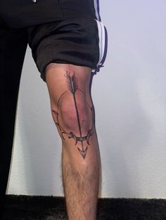 a man's leg with an arrow tattoo on it