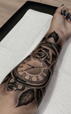 a woman's arm with a clock and rose tattoo on it