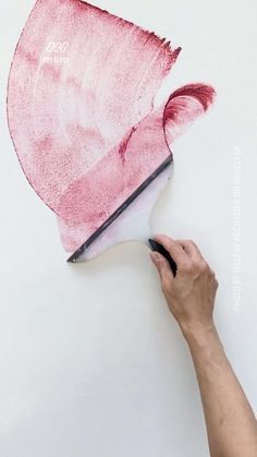 someone is drawing on the wall with pink paint