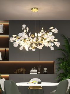 a modern dining room with white flowers on the chandelier