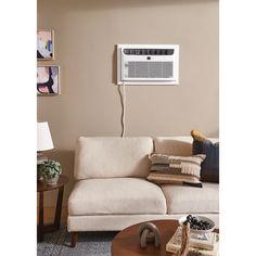 a living room with a couch, table and air conditioner mounted on the wall