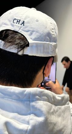 a man wearing a white hat and holding a cell phone