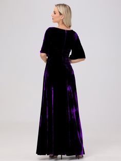 a woman wearing a purple velvet dress with short sleeves and an open back, standing in front of a white background