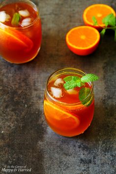 two glasses filled with orange juice and garnished with mint