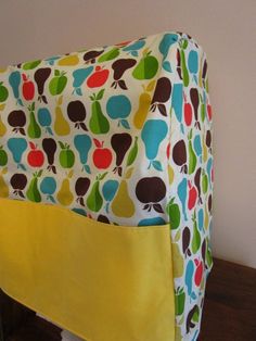 a close up of a bag on a table with an apple print fabric covering it