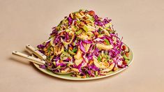 a plate full of coleslaw with chopsticks on the side