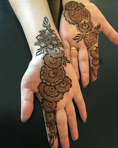 two hands with henna tattoos on them