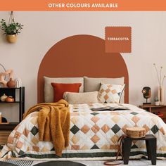 there is a bed with orange and brown colors in the room, it has a blanket on top