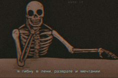 a skeleton sitting on the ground in front of a computer screen with words written below it