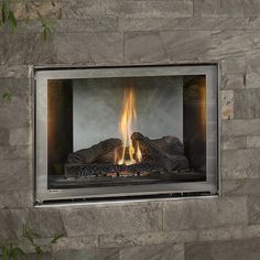 a fire burning inside of a fireplace in a stone wall