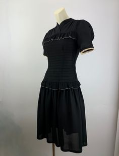 Cute 1940'S black rayon dress with a fitted bodice and a drop waist. There is this pleated flouncy trim that lines the chest and wraps around the drop waist. There is an attached belt that ties in the back. Super sweet. The sleeves are short and puffy. There is a metal talon side zipper as well as 4 cloth covered buttons in back along the neckline. The skirt is rather short and flirty, which reminds me of cute baby doll dresses. This dress is in EXCELLENT VINTAGE CONDITION... no real issues to p Puffy Sleeve Dress Vintage, Perfect Objects, Dropped Waist Dress, 1940s Fashion Women, Twenties Style, 50s Outfits, Vintage 90s Dress, Flare Shirt, Vintage Party Dresses