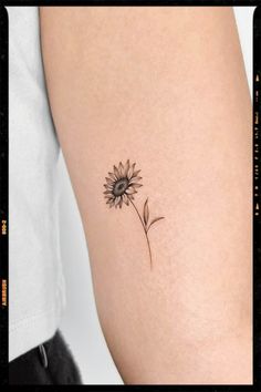 a small sunflower tattoo on the arm