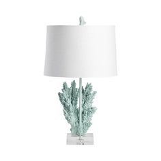 a table lamp that is on top of a white base with a light blue coral