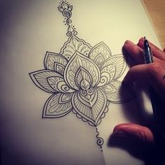 a person is drawing on paper with a pen and inking the design in it