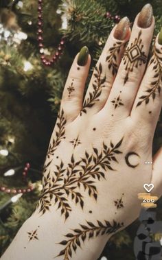 a woman's hand is decorated with hennap and stars on her palm