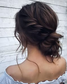 the back of a woman's head, with her hair in a low bun