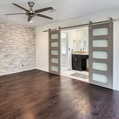 an empty room with wood floors and sliding doors