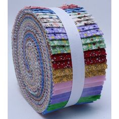 a roll of multicolored fabric with white ribbon on top of each one in different colors