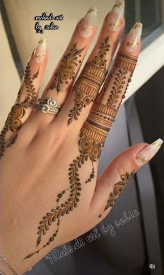 a woman's hand with henna tattoos on it