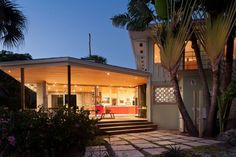 the house is lit up at night and has steps leading to it's front door