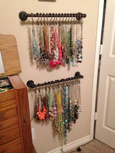 there is a rack with many necklaces hanging on the wall next to a door