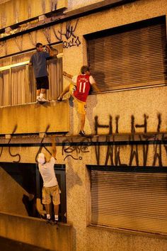 two men standing on the side of a building