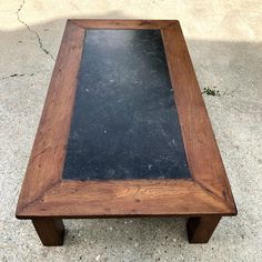 a wooden table with a black slate top