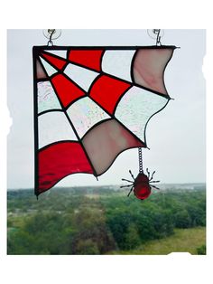 a red and white stained glass hanging from a window