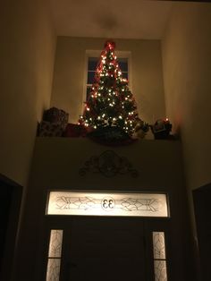 a christmas tree is lit up above the door