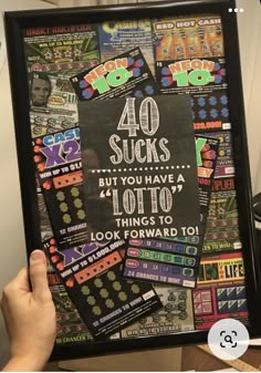 a person holding up a framed poster with the words 40 sucks but you have 4 lotto