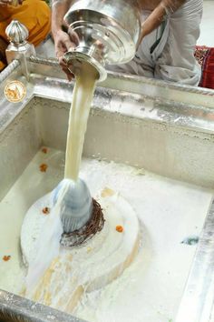 a person pouring water into a metal sink