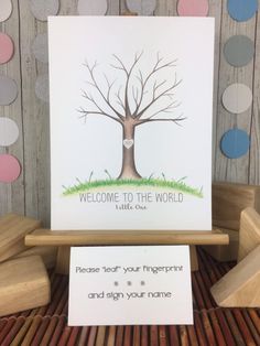 a welcome to the world card with a tree on it