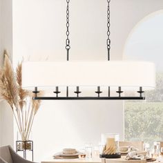 a dining room table and chairs with a light fixture hanging from the ceiling over it