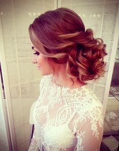 a woman with long hair in a wedding dress looking out the window at something behind her