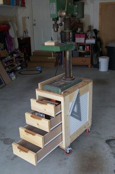 a workbench with drawers and a driller on it's side in a garage