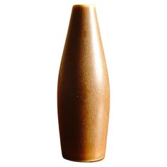 a brown vase sitting on top of a white table