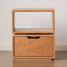 an empty wooden box on the floor with its lid open to reveal a shelf for storing items