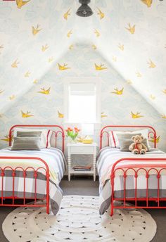 two beds in a bedroom with birds painted on the walls