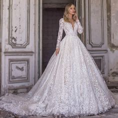 a woman in a white wedding dress standing outside an old building