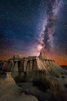 the milky shines brightly in the night sky above an eroded outcropping