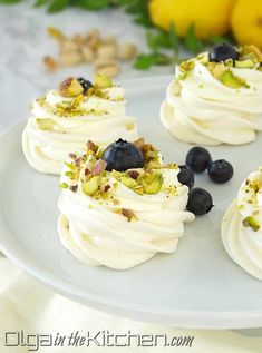 small desserts with white frosting and blueberries on a plate