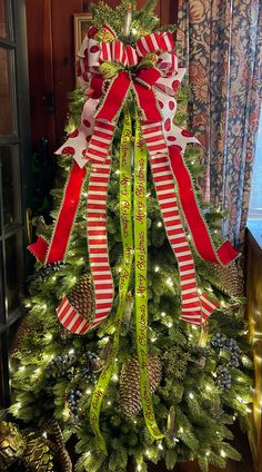 a decorated christmas tree with red and white bows