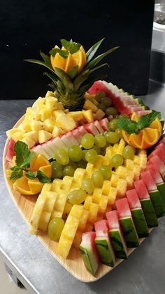 a platter filled with different types of fruit on top of a metal countertop