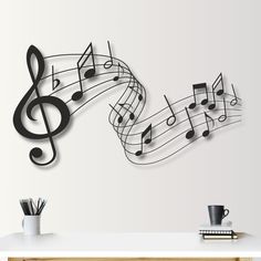 a wall with musical notes on it and a coffee cup next to it in front of the wall