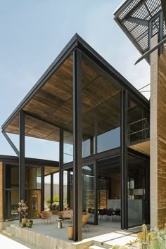 an open patio area with chairs and tables in front of a wooden structure on the side of a building