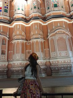 a woman standing in front of a tall building