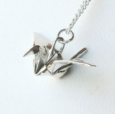 This is a TRUE origami crane pendant, folded from a sheet of fine silver. Unlike many origami necklaces you may see, this is folded by hand, not mass produced from a stamp or mold to look like origami. Because I fold each one by hand myself, there will be slight variations in the details. Origami cranes have been a symbol of peace and good luck for centuries.  The crane, or "tsuru" is a classic origami design. Its often the first animal many folders learn. Paper cranes are given to people who ar Origami Accessories, Unique Stores, Crane Necklace, Origami Necklace, Origami Jewelry, Holiday List, Origami Design, Precious Metal Clay, Origami Crane